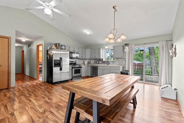 554 N Harvard Ave, Endeavor, WI 53930 - kitchen featuring appliances with stainless steel finishes, light countertops, vaulted ceiling, gray cabinets, and decorative backsplash