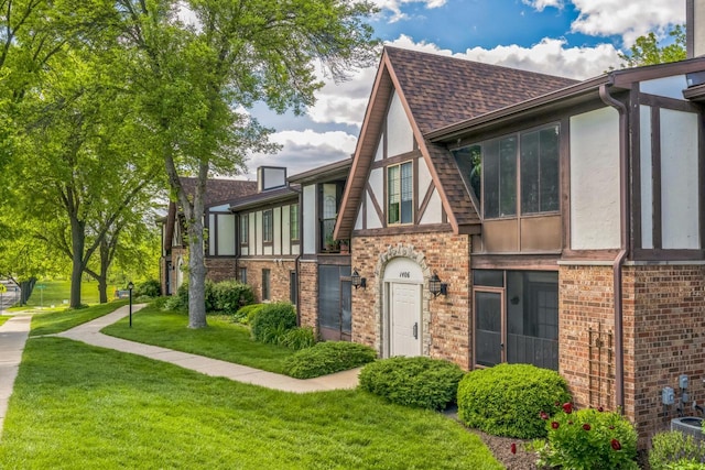 1402 Wheeler Rd Unit A, Madison, WI 53704 - view of front of house with stucco siding, brick siding, a front yard, and roof with shingles