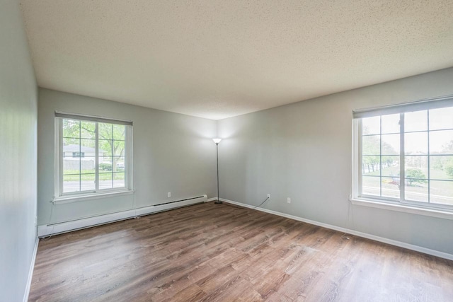 1402 Wheeler Rd Unit A, Madison, WI 53704 - spare room featuring a baseboard heating unit, wood finished floors, baseboards, and a textured ceiling