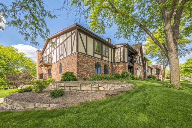 1402 Wheeler Rd Unit A, Madison, WI 53704 - back of house featuring brick siding, a balcony, a lawn, and stucco siding