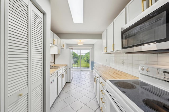 1402 Wheeler Rd Unit A, Madison, WI 53704 - kitchen with white appliances, backsplash, light tile patterned floors, white cabinets, and a sink