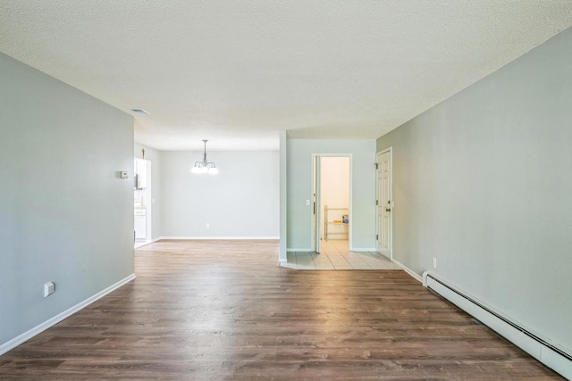 1402 Wheeler Rd Unit A, Madison, WI 53704 - empty room featuring a baseboard heating unit, a chandelier, wood finished floors, baseboards, and a textured ceiling