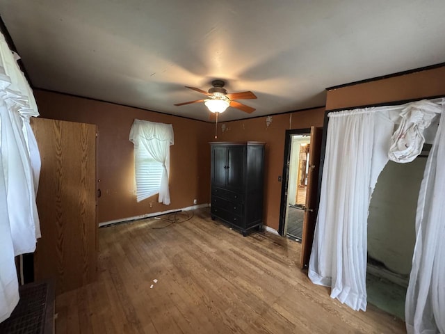 8444 Fish Hatchery Rd, Burlington, WI 53105 - unfurnished bedroom with wood finished floors, baseboards, and ceiling fan
