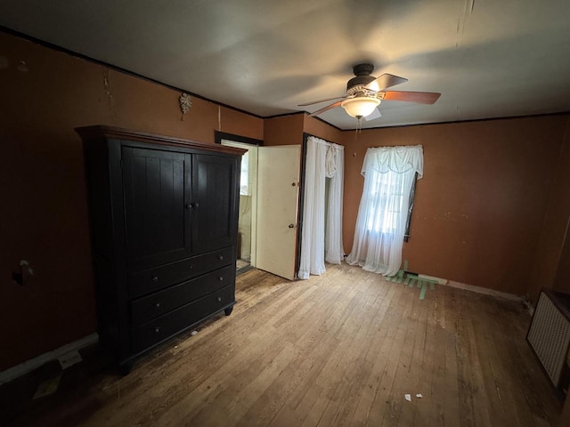 8444 Fish Hatchery Rd, Burlington, WI 53105 - unfurnished bedroom with wood-type flooring, baseboards, and a ceiling fan