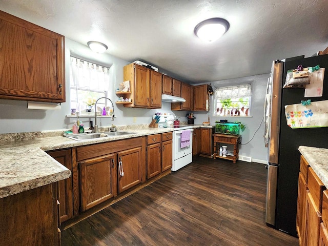 1130 10th St S, Wisconsin Rapids, WI 54494 - kitchen with white range with electric cooktop, a sink, under cabinet range hood, freestanding refrigerator, and dark wood finished floors