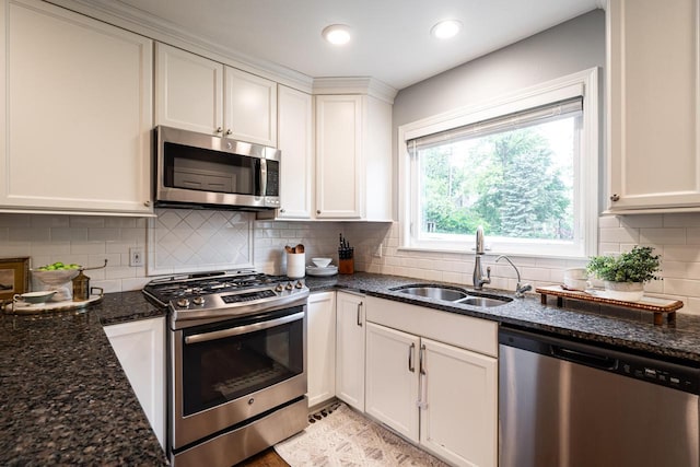 640 Crystal Ln, Elm Grove, WI 53122 - kitchen featuring stainless steel appliances, a sink, white cabinetry, dark stone countertops, and decorative backsplash