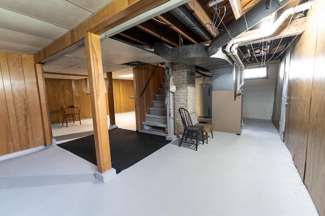 1816 Goodland Ave, Tomah, WI 54660 - basement featuring wood walls, electric water heater, stairway, and heating unit