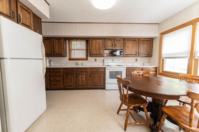 1816 Goodland Ave, Tomah, WI 54660 - kitchen featuring white appliances, a sink, light countertops, and light floors