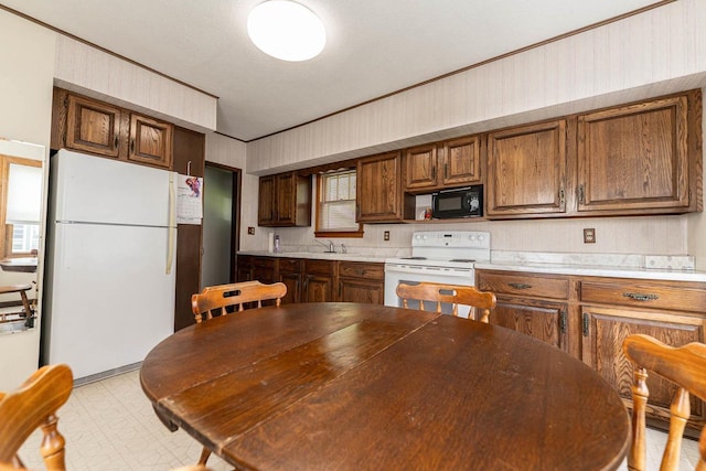 1816 Goodland Ave, Tomah, WI 54660 - kitchen featuring white appliances, a sink, light flooring, light countertops, and brown cabinets