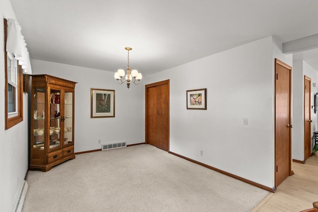 404 W Albert St, Portage, WI 53901 - unfurnished room with a chandelier, baseboards, and light colored carpet