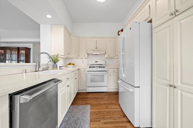 N26W30255 Maple Ave, Pewaukee, WI 53072 - kitchen with white appliances, a sink, under cabinet range hood, recessed lighting, and light countertops