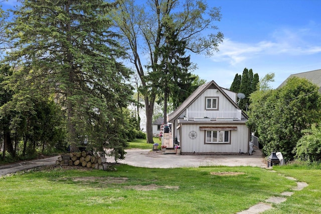 N26W30255 Maple Ave, Pewaukee, WI 53072 - back of property featuring a lawn, a balcony, and board and batten siding
