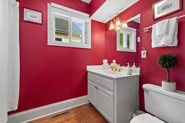 N26W30255 Maple Ave, Pewaukee, WI 53072 - bathroom featuring vanity, wood finished floors, toilet, and baseboards