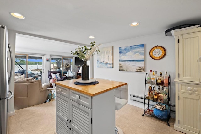 N26W30255 Maple Ave, Pewaukee, WI 53072 - kitchen with butcher block counters, freestanding refrigerator, recessed lighting, open floor plan, and light tile patterned flooring