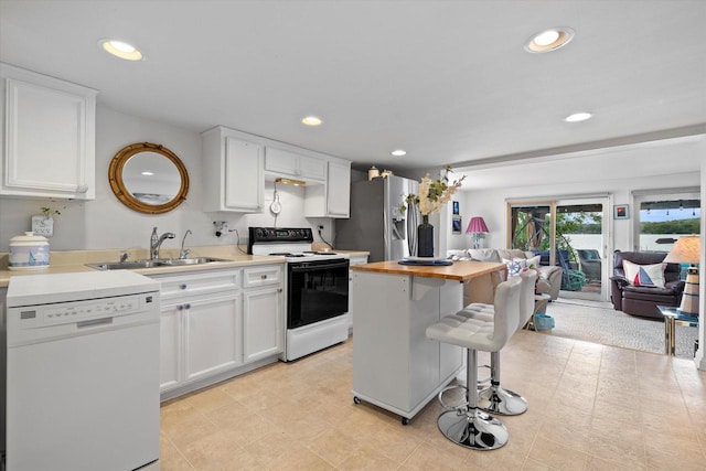N26W30255 Maple Ave, Pewaukee, WI 53072 - kitchen featuring white appliances, a sink, white cabinetry, butcher block counters, and a breakfast bar
