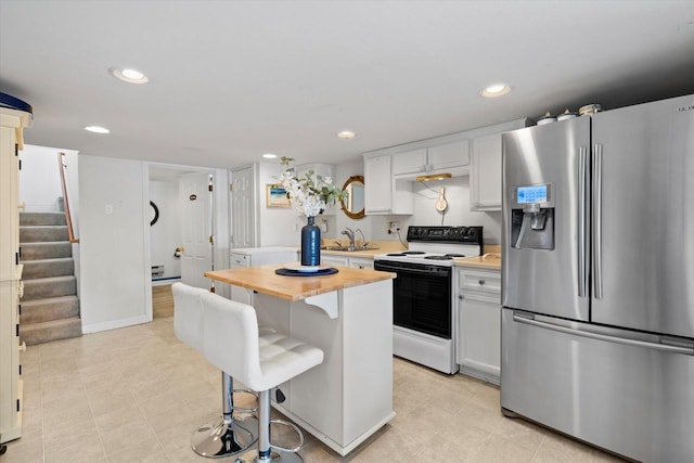 N26W30255 Maple Ave, Pewaukee, WI 53072 - kitchen with stainless steel refrigerator with ice dispenser, white electric range, a sink, a breakfast bar, and butcher block countertops