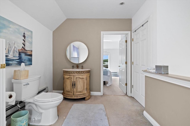 N26W30255 Maple Ave, Pewaukee, WI 53072 - bathroom featuring a baseboard heating unit, toilet, vanity, vaulted ceiling, and baseboards