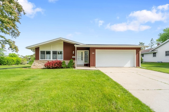 4998 Sterling Dr, Greendale, WI 53129 - view of front facade with an attached garage, concrete driveway, a front yard, and stone siding