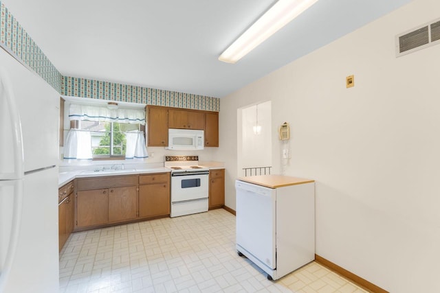 4998 Sterling Dr, Greendale, WI 53129 - kitchen featuring white appliances, a sink, light countertops, baseboards, and brown cabinets