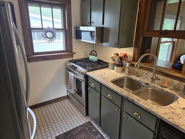 3609 Gregory St, Madison, WI 53711 - kitchen with stainless steel appliances, a sink, baseboards, decorative backsplash, and glass insert cabinets
