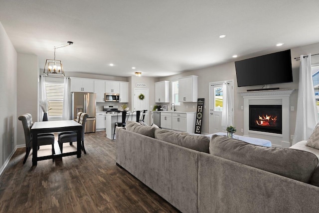 972 Margarets Way, Belleville, WI 53508 - living room featuring dark wood-type flooring, recessed lighting, a lit fireplace, and baseboards