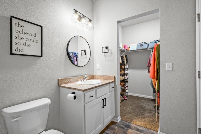972 Margarets Way, Belleville, WI 53508 - bathroom with vanity, toilet, wood finished floors, baseboards, and a walk in closet
