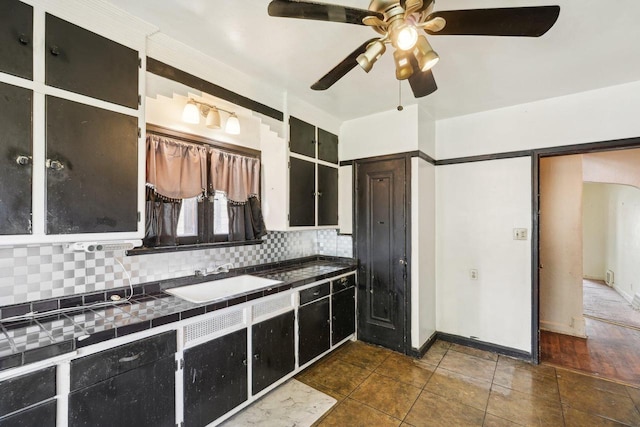 4182 N 13th St, Milwaukee, WI 53209 - kitchen featuring a sink, tile countertops, decorative backsplash, a ceiling fan, and dark cabinetry