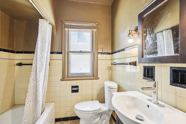 4182 N 13th St, Milwaukee, WI 53209 - bathroom featuring tile walls, toilet, a sink, shower / bath combo with shower curtain, and a wainscoted wall