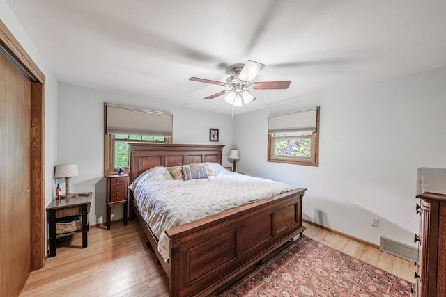 12105 W Shawnee Pass, Mequon, WI 53097 - bedroom with light wood-style flooring, a closet, ceiling fan, and baseboards