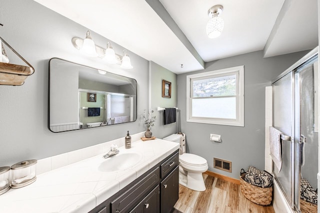 12105 W Shawnee Pass, Mequon, WI 53097 - full bathroom with a shower with door, vanity, wood finished floors, toilet, and baseboards