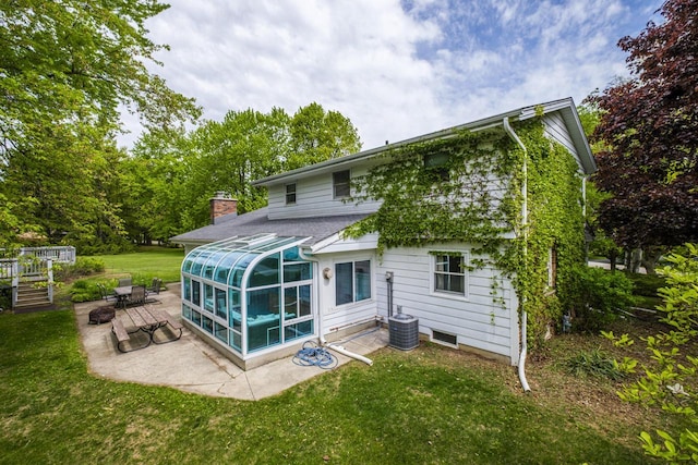 12105 W Shawnee Pass, Mequon, WI 53097 - rear view of property featuring a sunroom, a patio, a yard, and a chimney