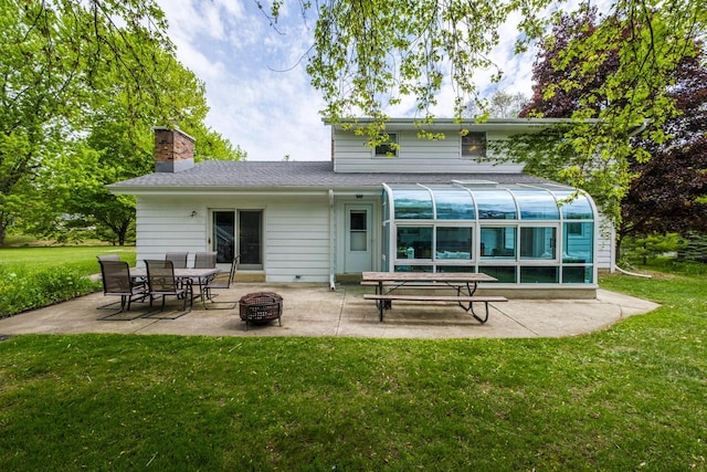 12105 W Shawnee Pass, Mequon, WI 53097 - back of house with a patio, a sunroom, a lawn, and an outdoor fire pit