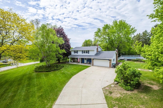 12105 W Shawnee Pass, Mequon, WI 53097 - traditional-style home with a porch, a front lawn, an attached garage, concrete driveway, and a chimney
