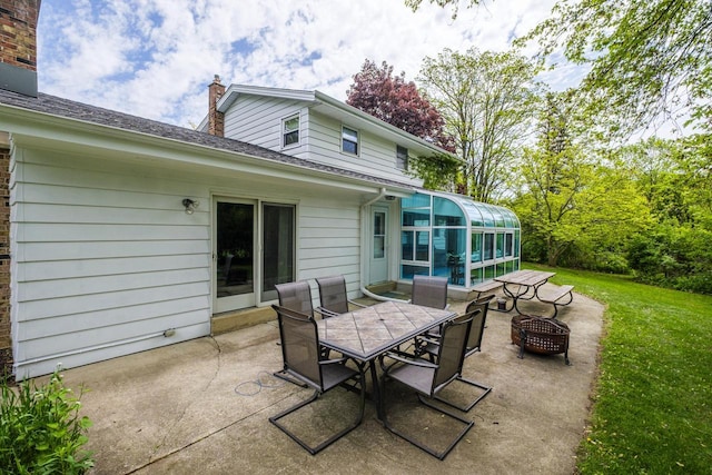12105 W Shawnee Pass, Mequon, WI 53097 - view of patio / terrace featuring a sunroom, outdoor dining area, and a fire pit