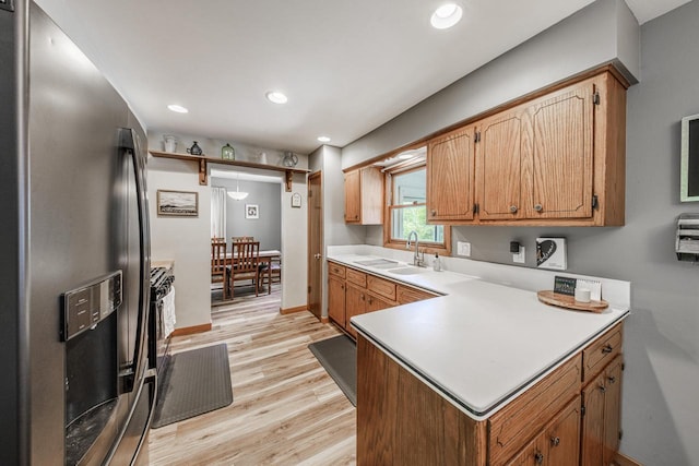 12105 W Shawnee Pass, Mequon, WI 53097 - kitchen featuring stainless steel fridge, a sink, light wood-style flooring, light countertops, and recessed lighting