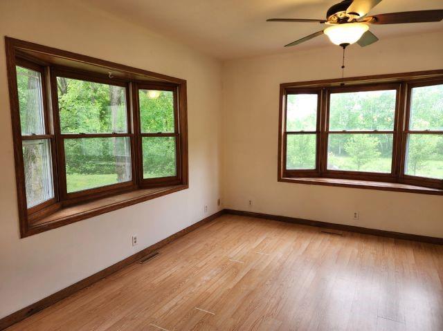 1561 240th Ave, Luck, WI 54853 - spare room featuring light wood-type flooring, baseboards, and a ceiling fan