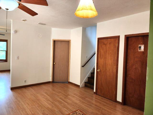 1561 240th Ave, Luck, WI 54853 - unfurnished room featuring wood finished floors, stairs, ceiling fan, and baseboards