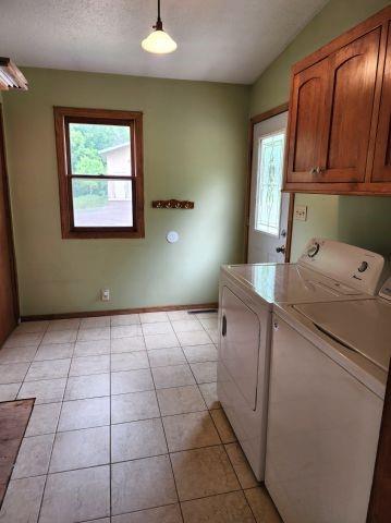 1561 240th Ave, Luck, WI 54853 - washroom with cabinet space, separate washer and dryer, baseboards, and light tile patterned floors