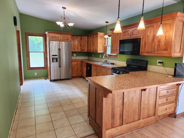 1561 240th Ave, Luck, WI 54853 - kitchen featuring black appliances, a sink, a peninsula, a chandelier, and vaulted ceiling