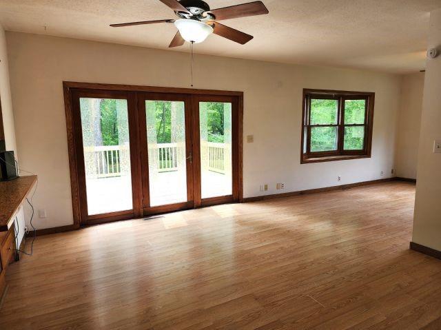 1561 240th Ave, Luck, WI 54853 - unfurnished living room featuring healthy amount of natural light, light wood-style flooring, baseboards, and a ceiling fan