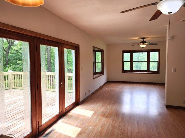 1561 240th Ave, Luck, WI 54853 - spare room featuring healthy amount of natural light, light wood finished floors, baseboards, and ceiling fan