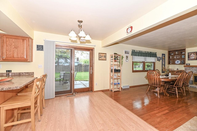 7538 S 74th St, Franklin, WI 53132 - dining space with a chandelier, light wood finished floors, healthy amount of natural light, and baseboards