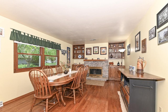 7538 S 74th St, Franklin, WI 53132 - dining area featuring a stone fireplace, dark wood-type flooring, baseboards, and built in shelves