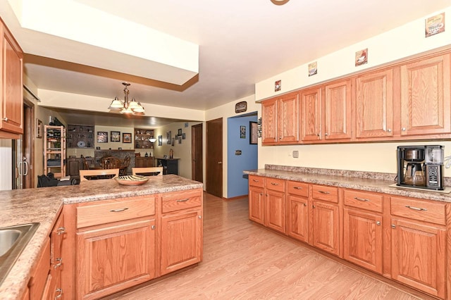 7538 S 74th St, Franklin, WI 53132 - kitchen with light wood-style flooring, light countertops, a peninsula, a sink, and pendant lighting