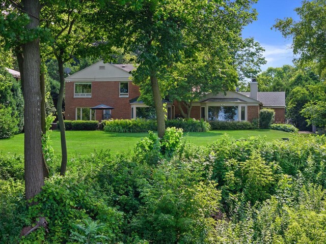 4696 N Lake Dr, Whitefish Bay, WI 53211 - view of front of home with brick siding, a front yard, and a chimney