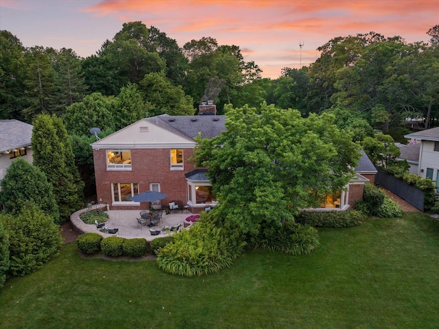 4696 N Lake Dr, Whitefish Bay, WI 53211 - back of property with a patio, a lawn, brick siding, and a chimney