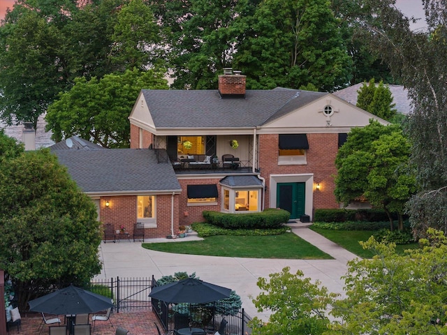 4696 N Lake Dr, Whitefish Bay, WI 53211 - view of front of house with a chimney, brick siding, roof with shingles, and a gate