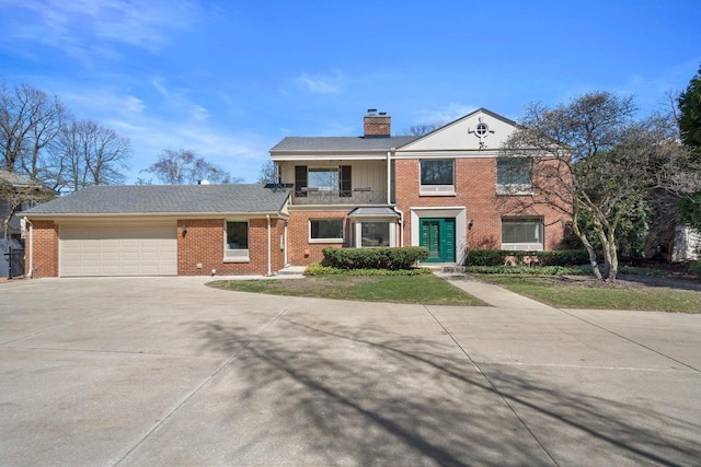 4696 N Lake Dr, Whitefish Bay, WI 53211 - view of front facade with a balcony, concrete driveway, brick siding, a chimney, and a garage
