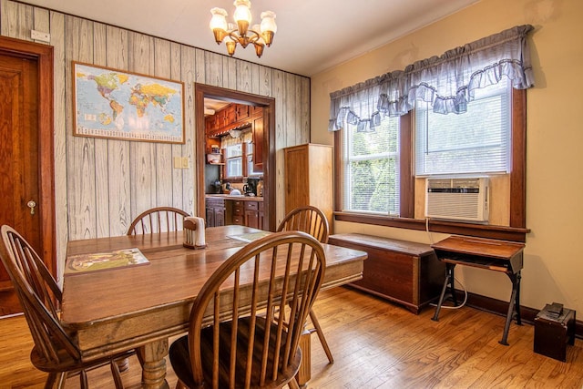 917 Whitewater Ave, Fort Atkinson, WI 53538 - dining space featuring a chandelier, wood finished floors, cooling unit, wood walls, and baseboards