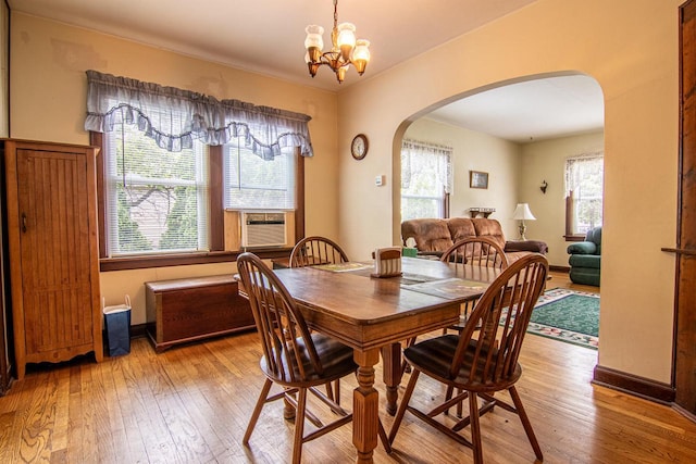 917 Whitewater Ave, Fort Atkinson, WI 53538 - dining space with arched walkways, wood-type flooring, a chandelier, and cooling unit